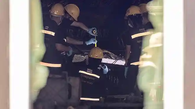 Forensic police officers inspect the interior of the Bangkok music bar after a deadly fire in Bangkok, Thailand, on July 14, 2026.