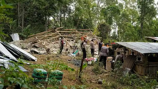 Police officers inspect a heavily damaged house after an earthquake in Manggarai, East Nusa Tenggara, Indonesia.