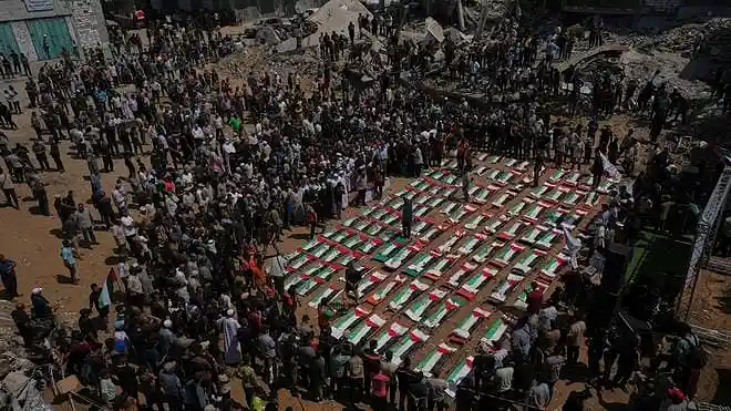 Bodies of members of the Hassayna and Abu Sharia families, recently recovered from the rubble of a 2023 Israeli airstrike, are wrapped in Palestinian flags during a mass funeral in Gaza City on August 4, 2026. | Photo Credit: AP